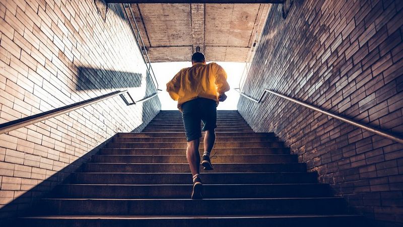 Man running up some stairs, shot from behind
